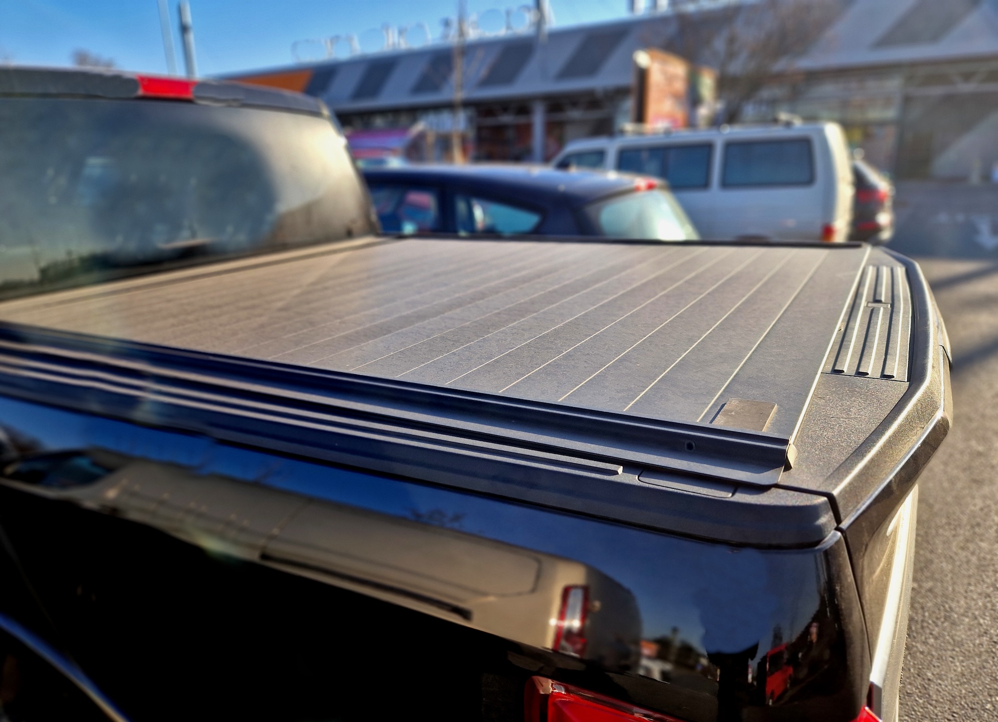 Image of a hinged bed cover on a red ford truck