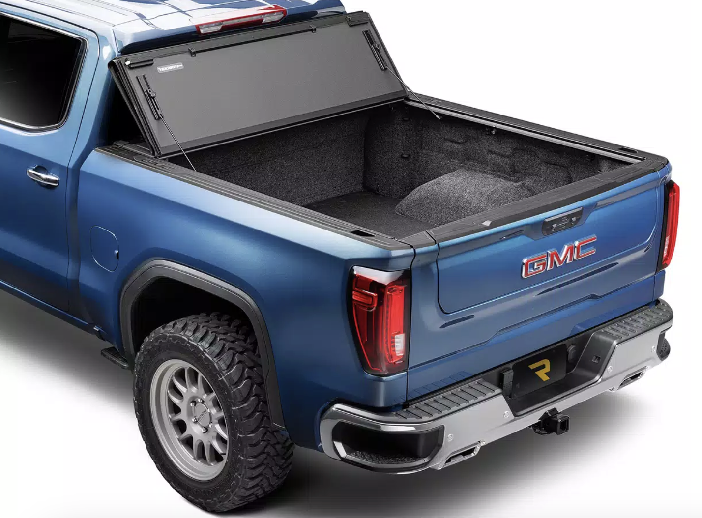 Image of a red Ford Raptor with a roll up bed cover to protect from the elements